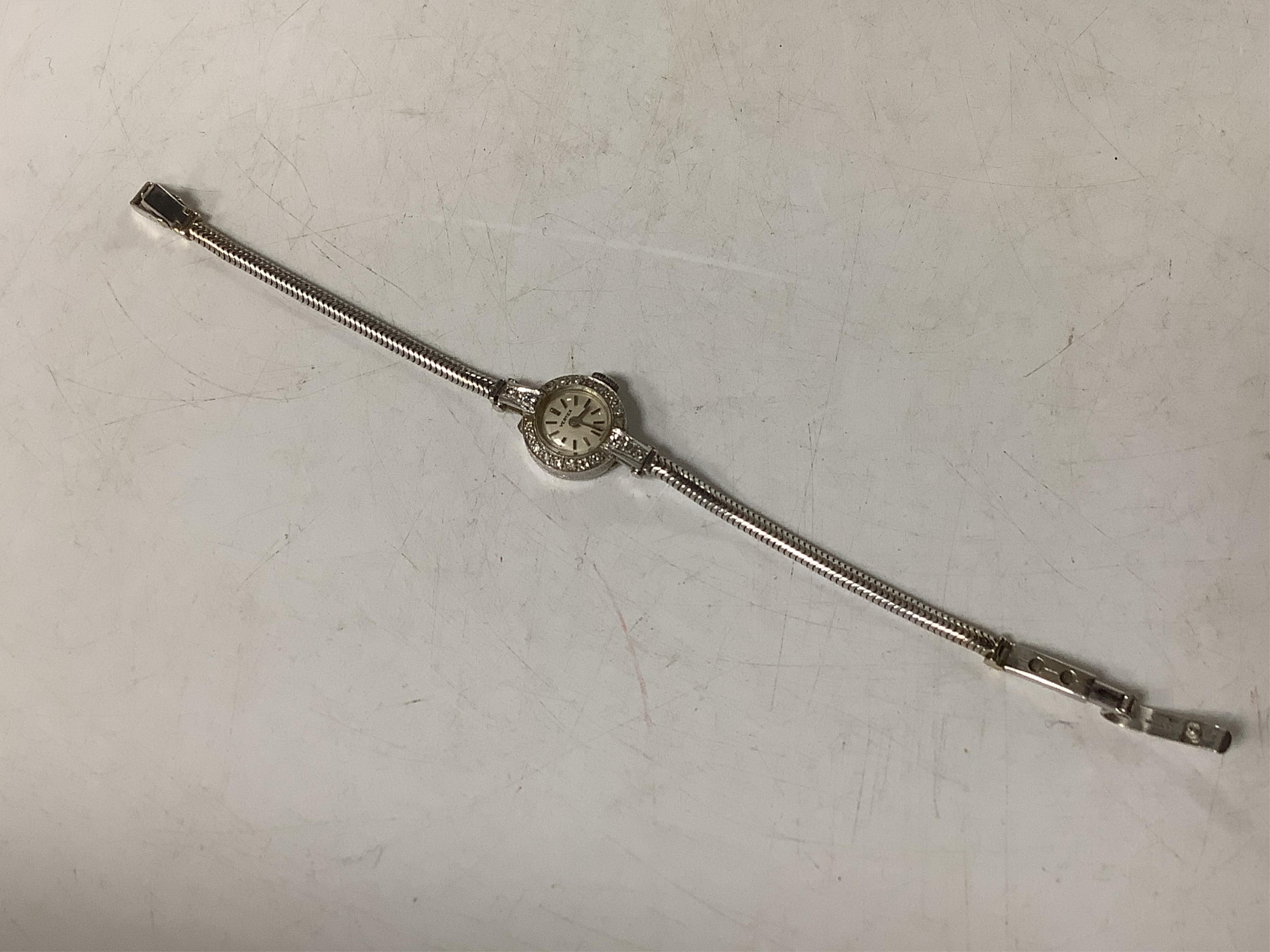 A lady's early 1970's white metal (stamped platinum) Vertex manual wind cocktail watch, with diamond set bezel and lugs, on a 9ct gold snake link bracelet, overall length 15.8cm, gross weight 12.9 grams.